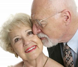 Every Day Sacred - closeup of a loving senior man gives his beautiful wife a kiss on the cheek