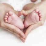 Every Day Sacred - Newborn baby feet in the mother hands