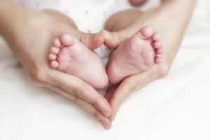 Every Day Sacred - Newborn baby feet in the mother hands
